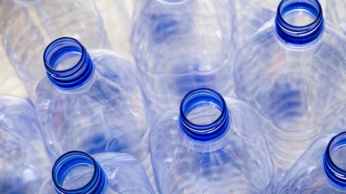 Clear plastic water bottles illustrating the clarity of PET & HDPE Bottles for Beverages.