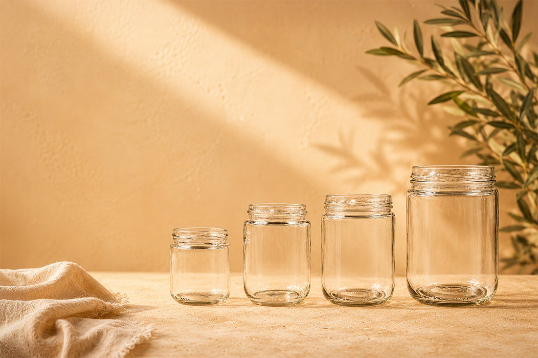 Group of empty clear glass short cylinder jars in multiple sizes – Richards Packaging